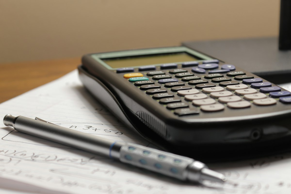 Taschenrechner und Stift auf Finanzunterlagen als Symbolbild für den Girokontowechsel.