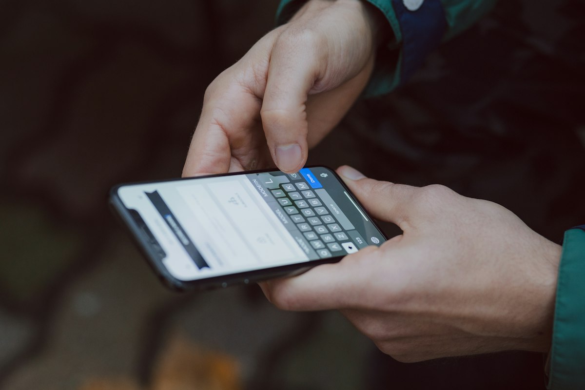 Person nutzt ein Smartphone für digitale Nachrichten; Symbolbild für WhatsApp und Chatverläufe.